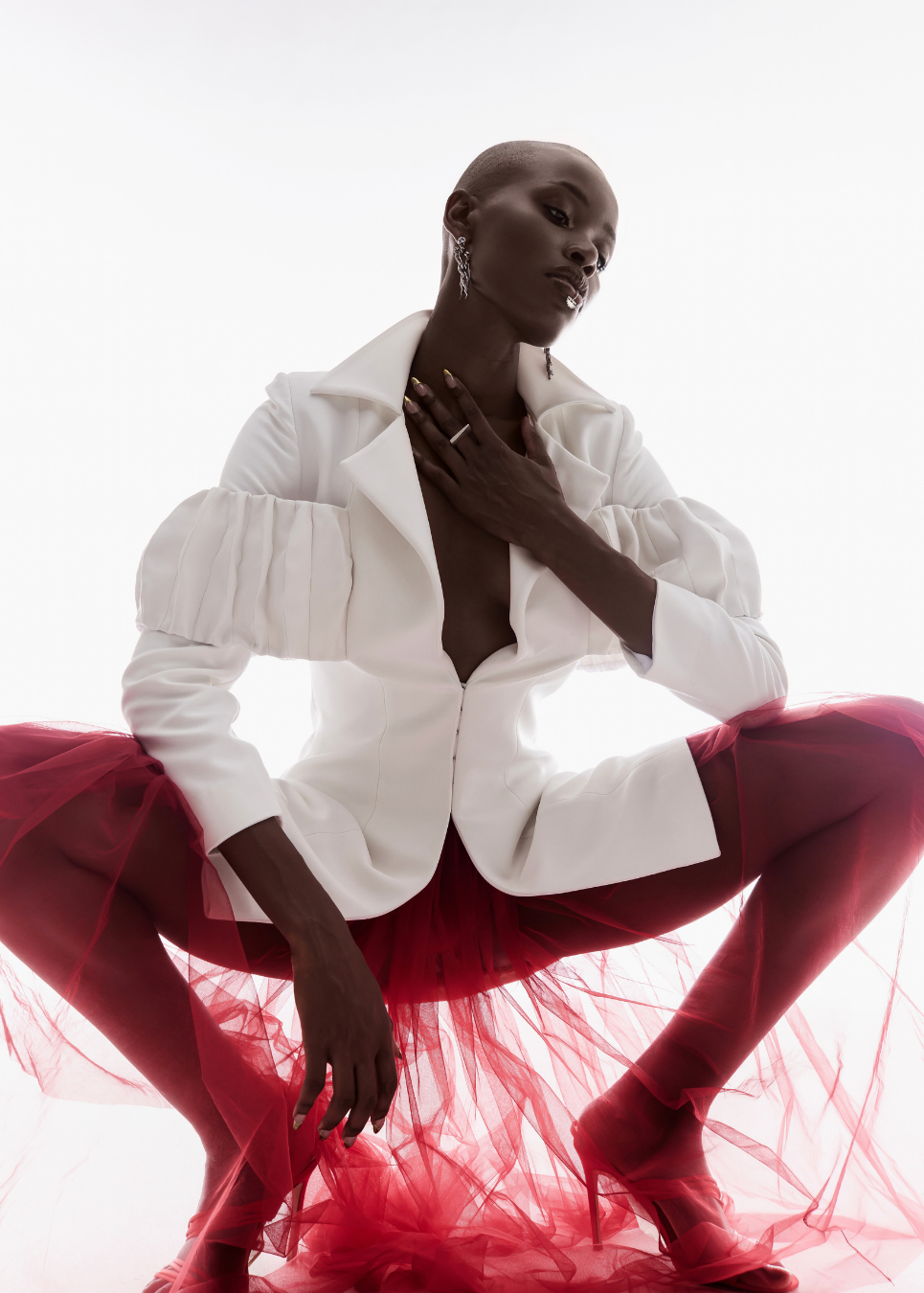Person wearing a white jacket and red skirt on a white background