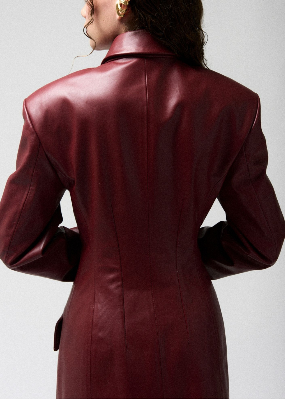 burgundy leather coat worn by a person on a light gray background