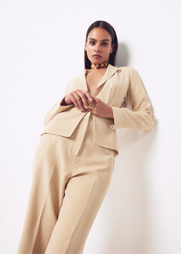 Woman wearing a beige suit against a white background