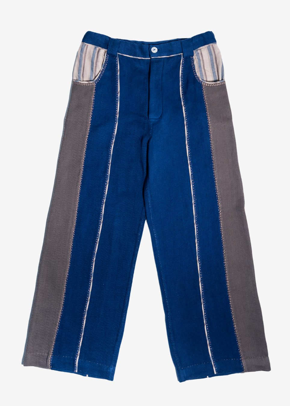 A pair of patchwork denim pants featuring a medium blue main body with wide gray side panels, striped inner pocket linings, and contrast white stitching, shown flat on a light gray background.