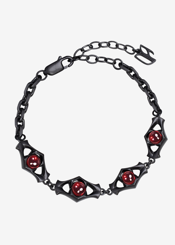A gothic-style black metal chain bracelet featuring bat-shaped links with red circular gemstone accents, displayed on a light gray background.