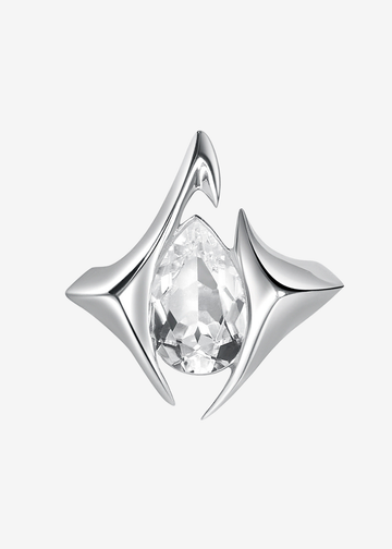 A silver-toned geometric ring featuring a central pear-cut clear gemstone, set against a plain light gray background.