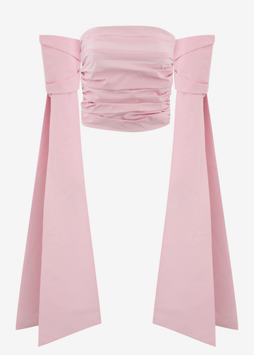 A light pink strapless bandeau top with dramatic side bows, shown against a plain light gray background.