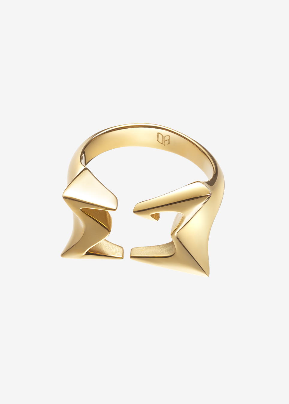 A gold geometric ring with a split band and angular, sculptural elements, shown on a plain light gray background.