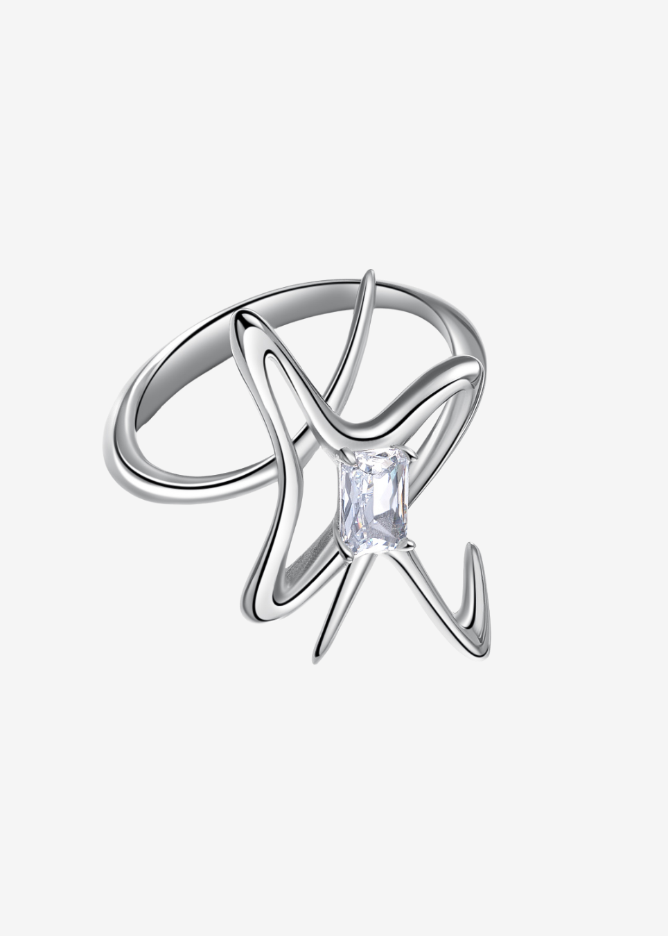 A silver ring featuring an abstract, swirling openwork design with a central clear rectangular gemstone, shown on a light gray background.