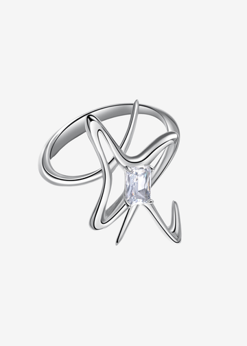 A silver ring featuring an abstract, swirling openwork design with a central clear rectangular gemstone, shown on a light gray background.
