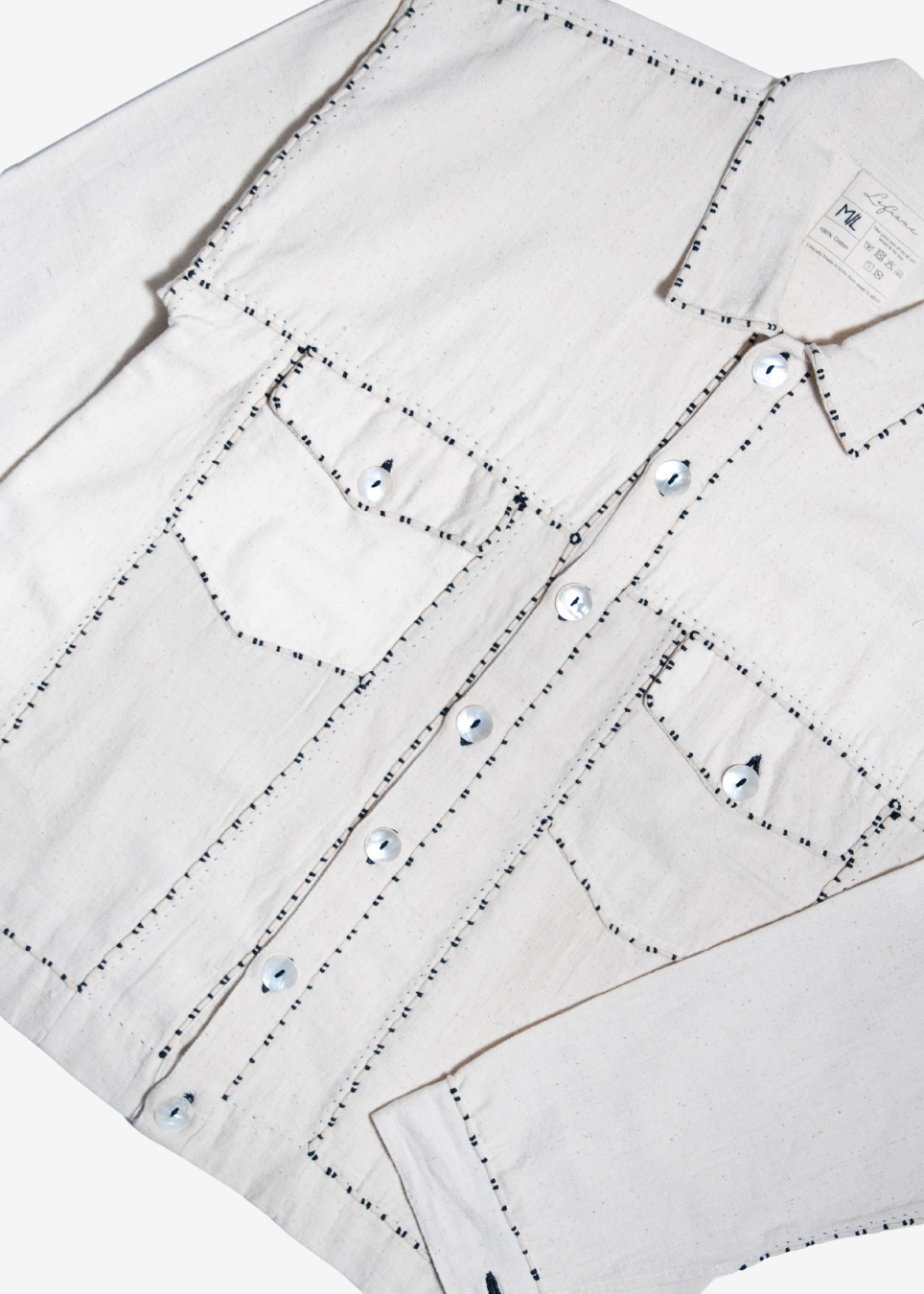 An off-white denim shirt jacket with decorative black dotted stitching outlining the chest pockets and front button closure, laid flat on a white background.