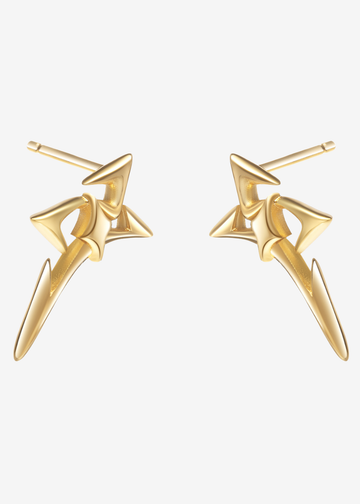 A pair of gold-toned geometric stud earrings with a star-like abstract design, shown on a plain light gray background.